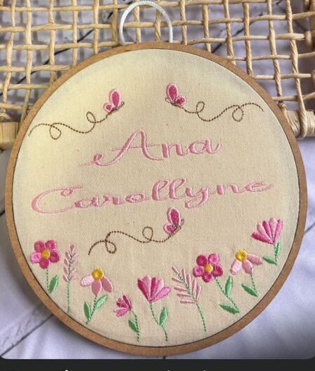 Bastidor decorativo bordado com o nome Ana Carollyne e flores coloridas